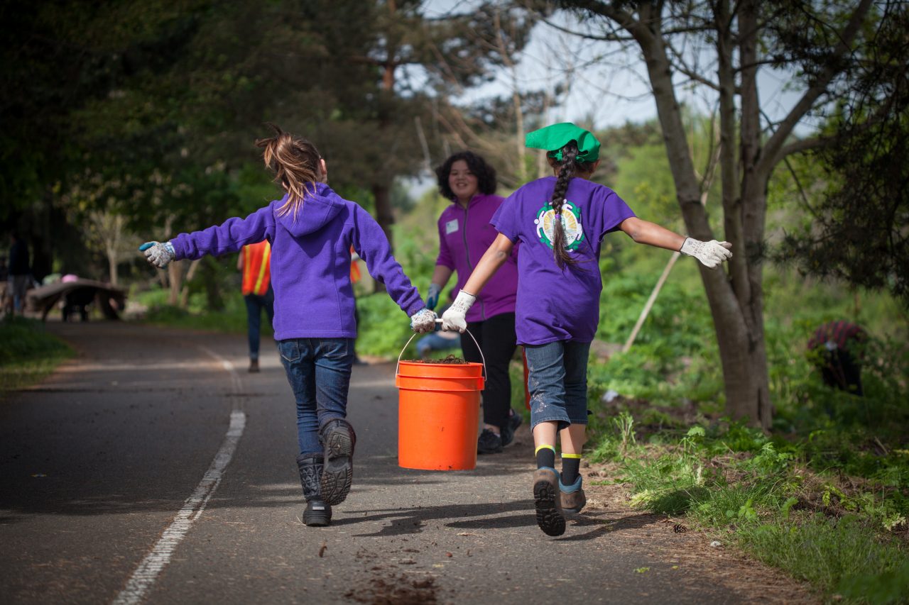 GreemTukwila_DuwamishAlive2016_Nick-Krittawat-Photo-Credit-55-1280×853 Two youth carrying a bucket together on the road